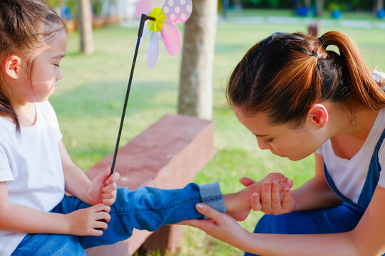 Family take care small child girl naughty in park until her have lesion on the feet