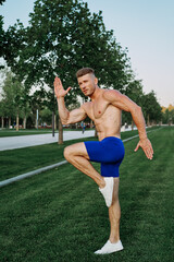 athletic man with a pumped-up torso exercise in the park fitness