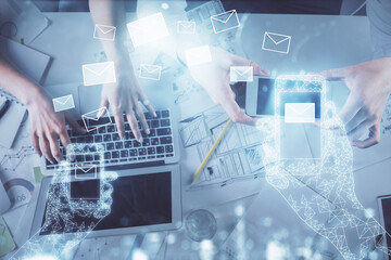 Double exposure of man and woman working together and the envelop hologram drawing. Computer background. Top View. Electronic mail concept.