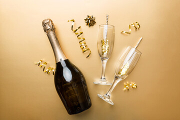 bottle of champagne with glasses and colorful confetti on colored background. top view flay lay