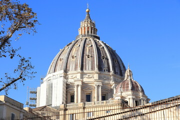 Fototapeta na wymiar St Peter's Basilica Dome During Renovation Works in 2021 Against a Bright Blue Sky in Rome, Italy