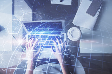 Double exposure of woman hands working on computer and world map hologram drawing. Top View. International business concept.