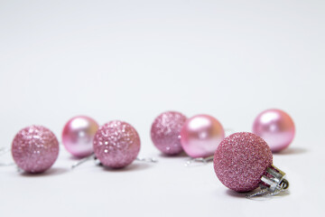 Pink Christmas tree ornaments on white background