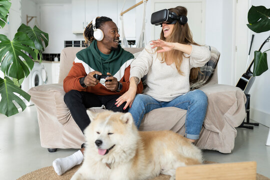 Couple enjoying leisure time in front of dog at home