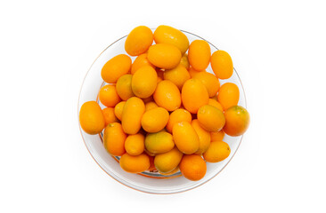 A glass bowl of kumquats isolated of white background