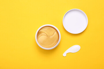 Jar of collagen golden patches on a yellow background. Anti-aging care