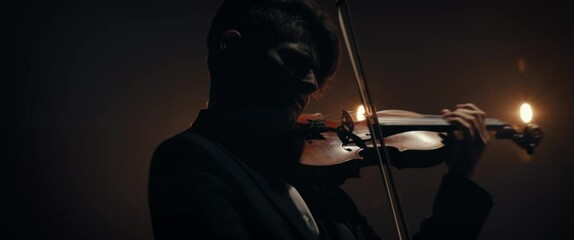 CU Portrait of young aspiring musician playing violin on a stage of a large venue. Shot with 2x anamorphic lens