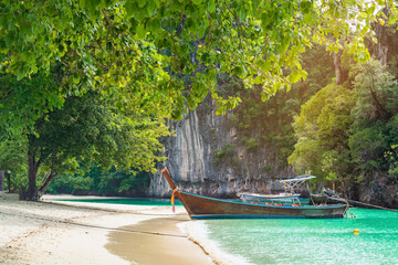Thai traditional wooden longtail boat and beautiful sand Railay Beach in Krabi province. Hong Island, Thailand.