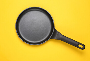 Pancake non-stick frying pan on yellow background