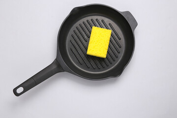 Grill pan with sponge on gray background