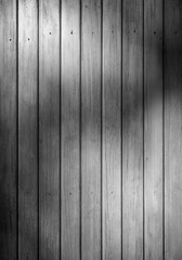 Front view of an old weathered and painted wooden wall or wood paneling. Abstract high resolution full frame textured background in black and white.