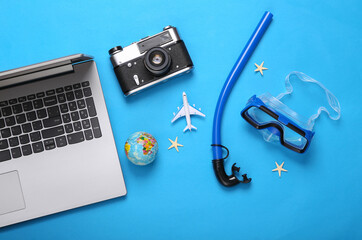 Diving set with travel accessories, laptop on a blue background. Beach vacation concept. Top view