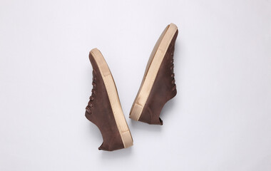 Mens brown leather sneakers on a gray background