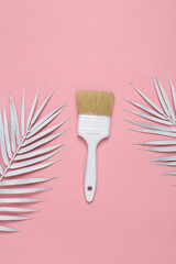 Bush with white painted palm leaves on a pink background. Minimal layout