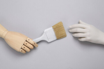 Hands holding paintbrush on blue pastel background. Creative layout