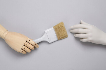 Hands holding paintbrush on blue pastel background. Creative layout