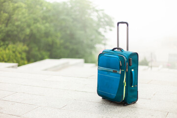 Travel luggage in an empty city with foggy weather. Travel concept
