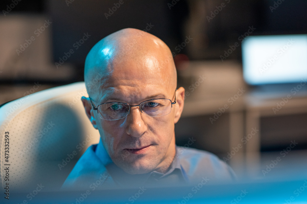 Leinwandbilder Head of mature bald it-manager or programmer looking at data on computer screen while working in office