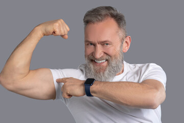 Mature bearded man showing his muscles
