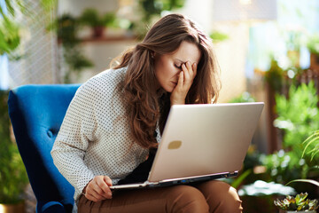 unhappy modern woman at modern home in sunny day using laptop