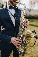 Stylish man in suit, musician, professional saxophonist in suit plays the saxophone. Photography,...