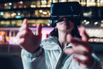 Woman in virtual reality headset gesturing at night