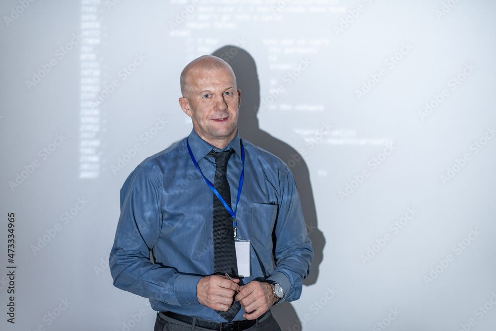 Poster Contemporary experienced coach standing by large interactive whiteboard with data while making presentation