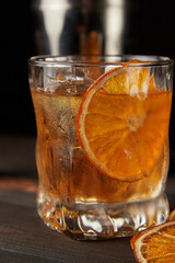 Old fashioned cocktail up close on a wooden background