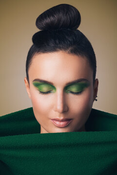 Beaitiful woman with green eye make-up looking down