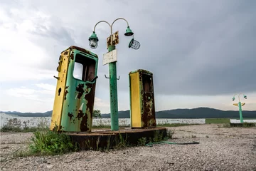 Fotobehang old and abandoned gas station on a forgotten highway, a mystical and gloomy atmospheric place dramatic sky © Vladimir Razgulyaev