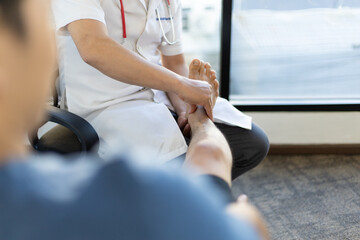 The doctor is diagnosing the pain in the patient's legs and ankles.