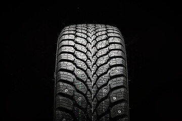 winter studded tire new photo from the front on a black background close-up