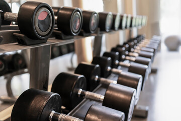 Obraz na płótnie Canvas sports dumbbells for training and fitness lie in a row in the gym, a symbol of a sporty lifestyle and health. fitness center