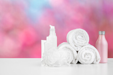 Spa still life with towels and skincare cosmetics against blurred background