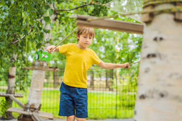 Little boy in a rope park. Active physical recreation of the child in the fresh air in the park....