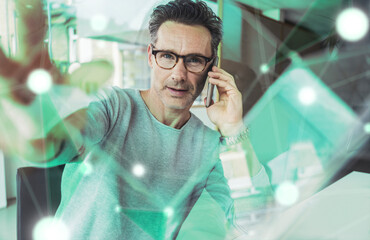 Businessman talking on smart phone and touching augmented business strategy at office