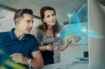 Businessman and colleague examining futuristic strategy in office