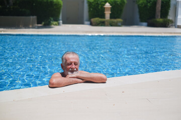 caucasian elder, senior mature man resting in swimming pool