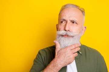Photo portrait of elder man looking empty space thoughtful isolated vivid yellow color background