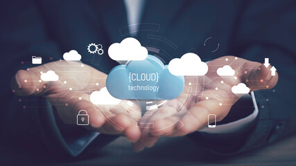 Naklejka premium Cloud technology,Technology transformation, Data security concept. Businessman hold digital cloud downloading and uploading data application with cloud icons and circuit boards in the background.