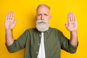 Naklejka premium Photo portrait of elder man serious showing stop enough sign with hands isolated vivid yellow color background