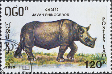 Cancelled postage stamp printed by Laos, that shows Javan Rhinoceros (Rhinoceros sondaicus), circa 1990. © ilapinto