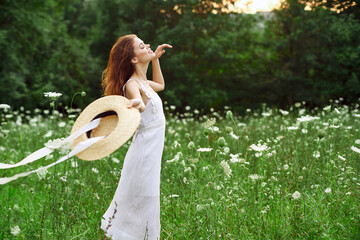 Woman in white dress and hat in a field with flowers lifestyle