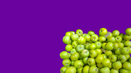 Pile of green apples on bright purple background. Grocery store. Natural fruits in supermarket or farmer market. Fresh food. Retail industry. Greengrocers shop. Freshness food flyer. Copy space. Ad.