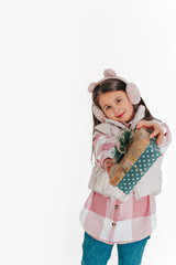 a girl in warm clothes presenting a gift on the white background. Space for text	
 