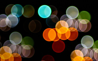 Bokeh circles from the lens on a black background. Abstract background. Selective focus