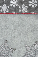 Gray and white snowflake border winter background on gray felt material