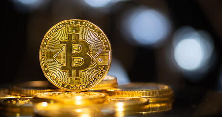 The golden bitcoin coin sits on a stack of cryptocurrencies.