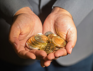 Businessman showing cryptocurrency coins on hand for saving money