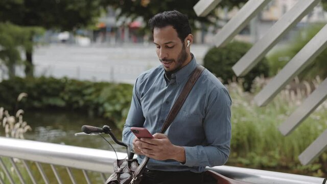 African american man sitting near bike and using mobile